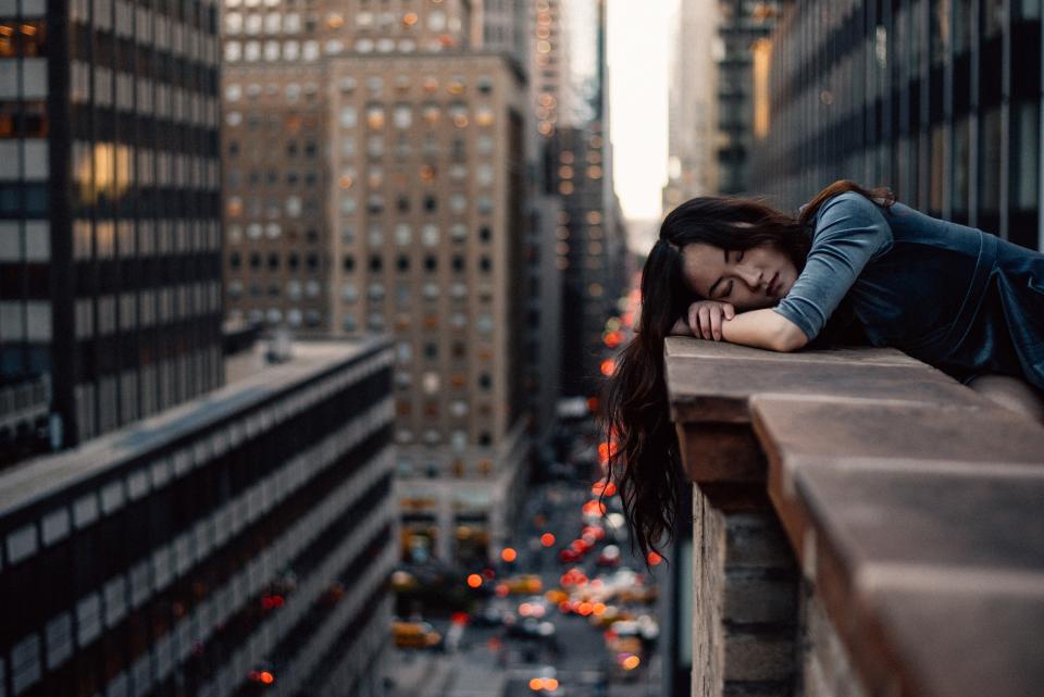 entrepreneur hanging over balcony looking over new york city